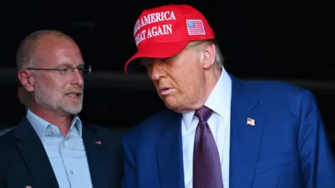 Getty Images Brendan Carr with President Trump at an event (File picture)