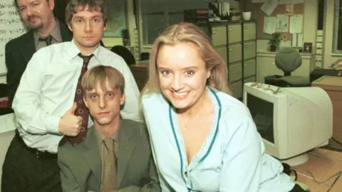 Picture shows (from back) Ricky Gervais as David Brent, Martin Freeman as Tim, MacKenzie Crook as Gareth and Lucy Davis as Dawn in the office