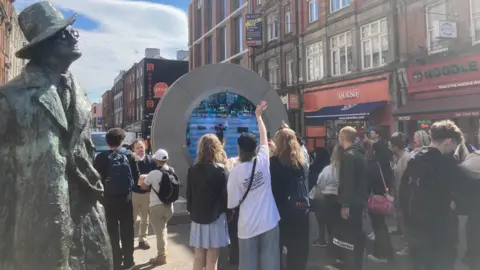 The livestream is beside a statue of James Joyce