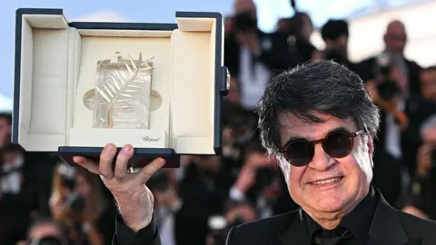 Iranian director Jafar Panah hold the  Palme d'Or trophy 
