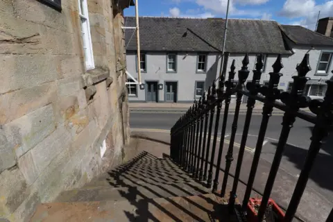 Billy McCrorie A stone staircase with a black railing up the side of it