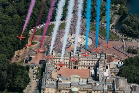 Ministry of Defence/EPA/Shutterstock An aerial image of the Red Arrows flypast, below which Buckingham Palace and huge crowds can be seen.