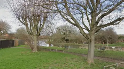 Green lawned area with water running through.