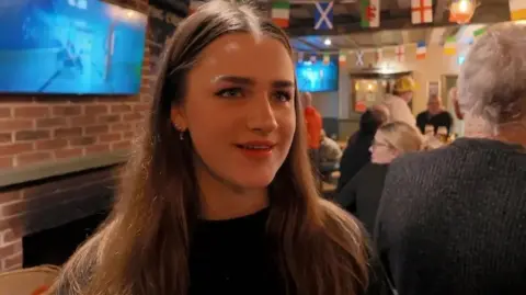 A woman standing in a pub