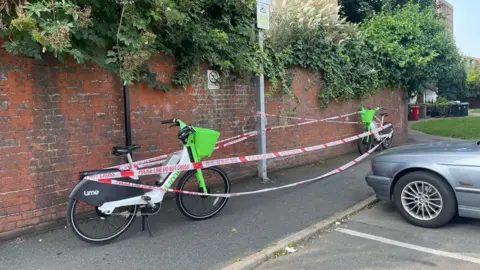 BBC/Anna O'Neill Two Lime bikes wrapped in police tape