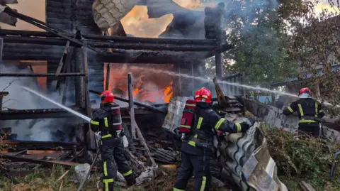 Firefighters work at the site of a residential area hit during Russian drone and missile strikes in Lviv 