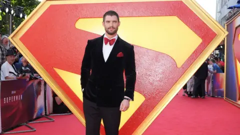 David Corenswet stands in front of the Superman logo in Leicester Square