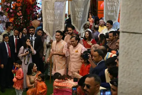 盖蒂图片社亿万富翁大亨、信实工业董事长穆克什·安巴尼 (Mukesh Ambani) (中右) 与家人于 2024 年 7 月 3 日在孟买的住所安蒂拉参加了儿子阿纳特·安巴尼 (Anant Ambani) 与拉迪卡·麦钱特 (Radhika Merchant) 婚礼前的传统婚礼仪式。 
