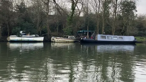 Environment Agency Three boats on the Thames in West Molesey, Surrey.