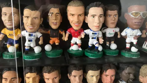 Warren Muggleton/BBC Two rows of Corinthian models behind a glass pane. The top row features some of England's squad, such as Frank Lampard and David Beckham.
