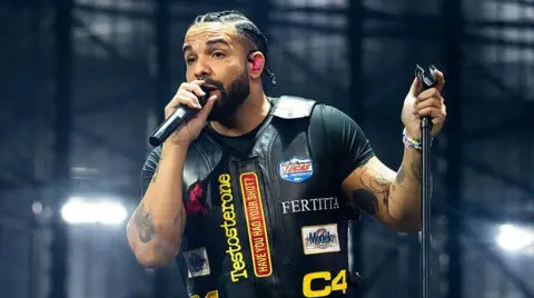 Drake holding a microphone stand