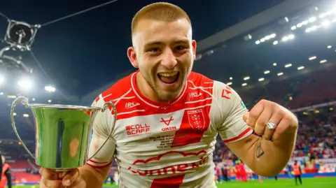 Hull KR's Mikey Lewis celebrates with the Rob Burrow Award trophy and his Grand Final winner's ring.