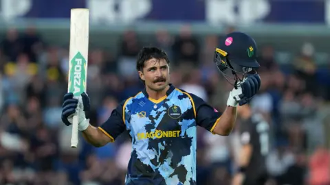 Glamorgan captain Kiran Carlson celebrates reaching his hundred against Somerset.