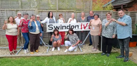Swindon IVC A group of people smiling outside as they drink prosecco and glasses of wine
