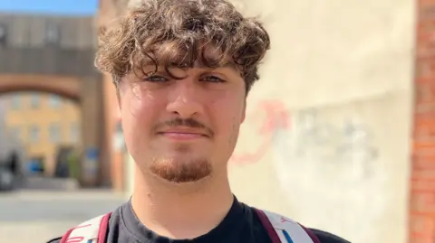 Primer plano de la cara de John Wright/BBC Man. Tiene cabello rizado, bigote y barba.