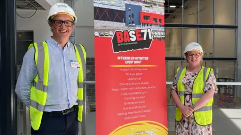 Matthew Stevens and Mandy Carlson either side a promotional banner for Base71, which reads: "Offering 20 activities every night".