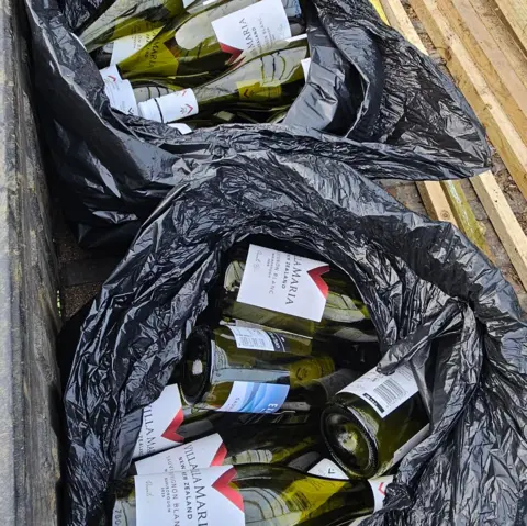 Submitted Two black bin bags full of empty, green wine bottles, mosly with the "Villa Maria" label