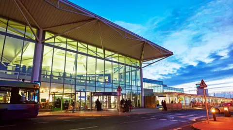 Exterior of Bristol airport departure lounge illuminated at dusk.