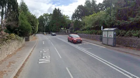 Google The A370 in Flax Bourton. It is a residential area with a bus stop. There are stone walls on either side of the carriageway and a footpath. 