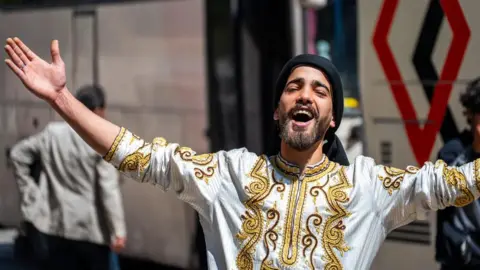 BBC Dancer wearing embroidered silk shirts welcoming convoy