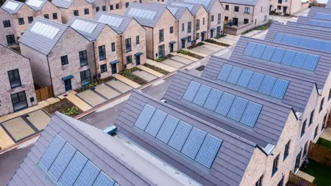 Getty Images Row of homes with solar panels