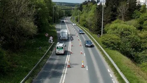 Jaggery | Geograph A stretch of the old Heads of the Valleys road with two rows of cones separating the two directions of travel. Traffic flows in both ways, with a 40mph sign and trees on either side of the road.