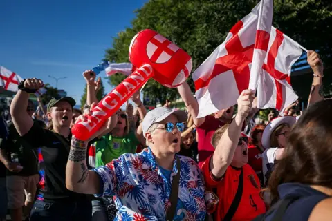 Getty Images A crowd of England supporters waving red and white flags and inflatable hammers arrive for the UEFA Women's Euro 2025 semi-final football match between England and Italy at the Stade de Geneve in Geneva, on July 22, 2025