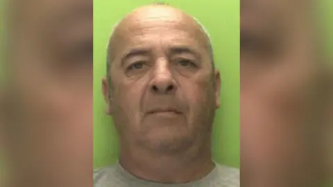 Nottinghamshire Police A police custody shot of a middle-aged bald man in a get t-shirt