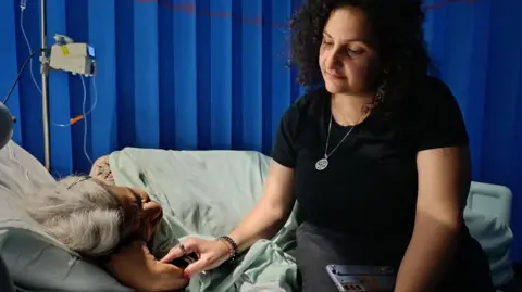 Mona Seif comforts her mother, Laila Soueif, as she receives treatment at Guy's and St Thomas' hospital in London (30 May 2025)