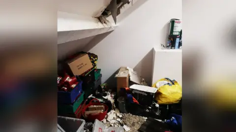 Northumbria Police A hole in the wall of a room, with debris across the floor