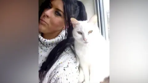 Mandy Hobbis Selfie with Mandy (left) and white Short hair cat 'Snowy' (right). Mandy has her head tilted towards Snowy, while he looks straight into the camera. 