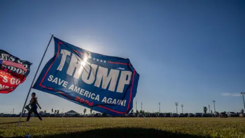Getty Images A person walks past Trump flags at a 'Save America' rally on October 22, 2022 in Robstown, Texas