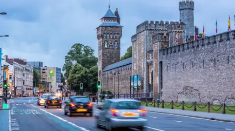 Getty Images Wide image of the road which comes into Cardiff next to the Castle. Blurred cars can be seen driving through the city centre.