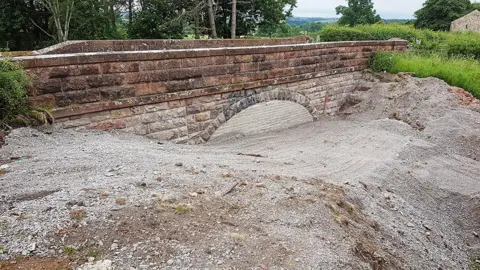 View of Great Musgrave Bridge with concrete under the arch and on surrounding area