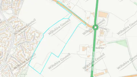 Wiltshire Council a map showing a blue outline around an area in a roughly rectangular shape with housing to the left and a major road and roundabout on the right 