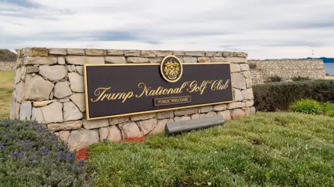 A sign for Trump's golf course overlooks a bluff in California