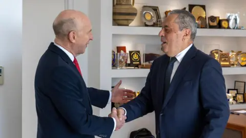 John Healey/X Jonathan Healey shakes the hand of the Cypriot defence minister