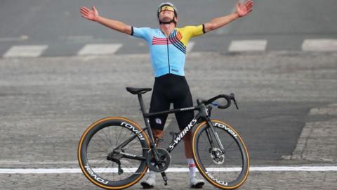 Remco Evenepoel with his bike after winning the road race at the 2024 Olympics
