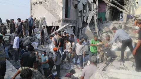 Mehr News/WANA via Reuters People looking for survivors in the rubble of the school in Minab 