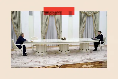 Sputnik/ AFP via Getty Images French President Emmanuel Macron (R) meets with Russian President Vladimir Putin (L) in Moscow in 2022 - they sit either end of a very long table, with no others
