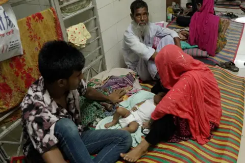 Hospital ward in Mymensingh, Bangladesh, where adults and children sit on the floor