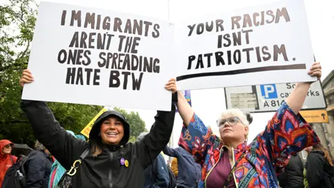 PA Media Anti-racism protesters hold placards aloft
