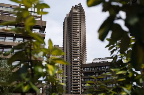 Getty Images One of the Barbican towers surrounded by other parts of the estate seen through green vegetation