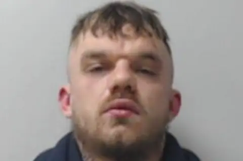 Police Scotland Ethan Kerr looking at camera in a police mugshot.