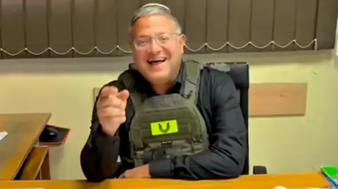 @itamarbengvir Israeli National Security Minister Itamar Ben-Gvir sits at a desk in an office in UNRWA's Qalandia training centre, in the occupied West Bank (25 August 2026)