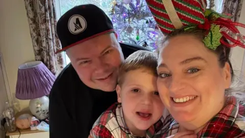 Selfie of Leo and his parents - he is wearing the same pyjamas as his mum and they are all smiling