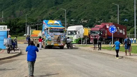 BBC / Sammy Awami Três caminhões vazios vistos no lado da Tanzânia da fronteira com o Malawi enquanto os motoristas andam sem rumo