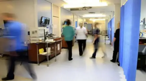 PA Media Medical staff in an NHS hospital ward.