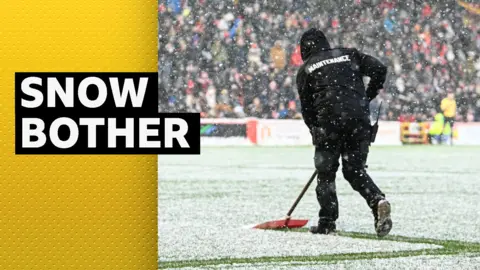 Snow being swept away at Pittodrie