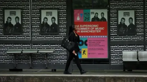 Reuters Posters of Oasis tour up at trams stop in Manchester
